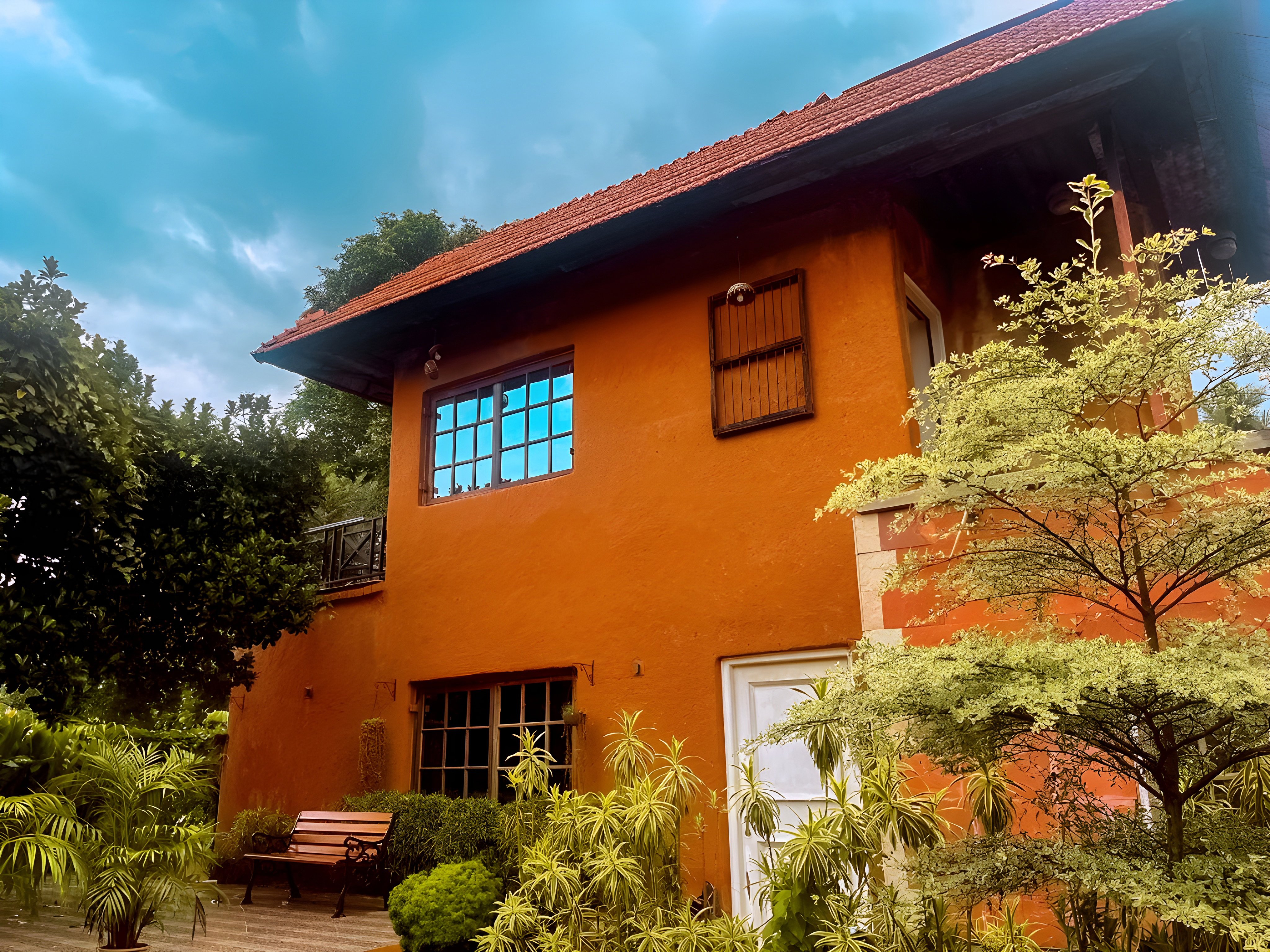 Bishnupur Farmhouse with terracotta red walls and lush natural garden, rural residential architecture in Bankura District West Bengal