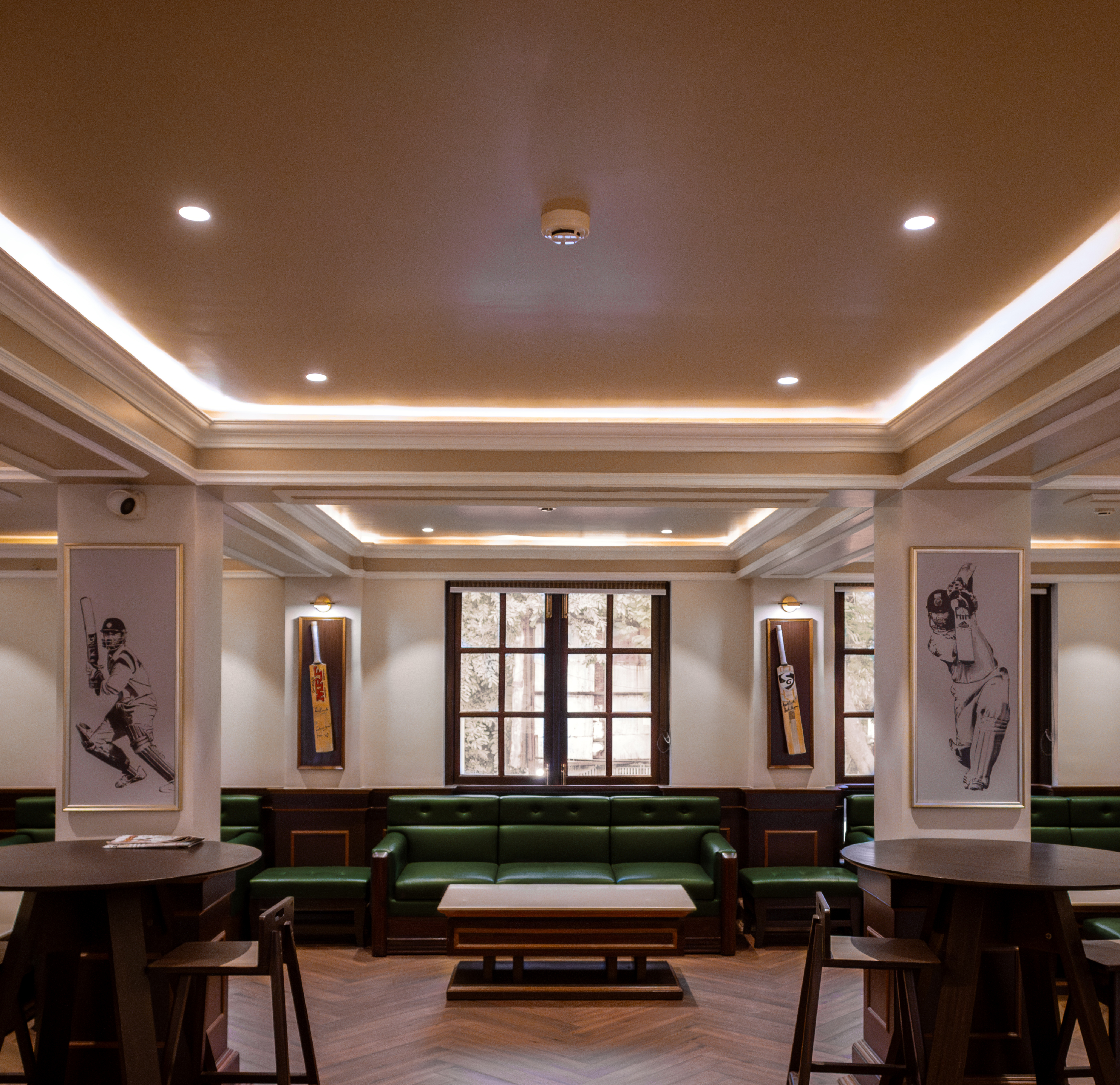Renovated CCFC Pool Pub interior with green leather seating, herringbone wood floors and sporting heritage artwork