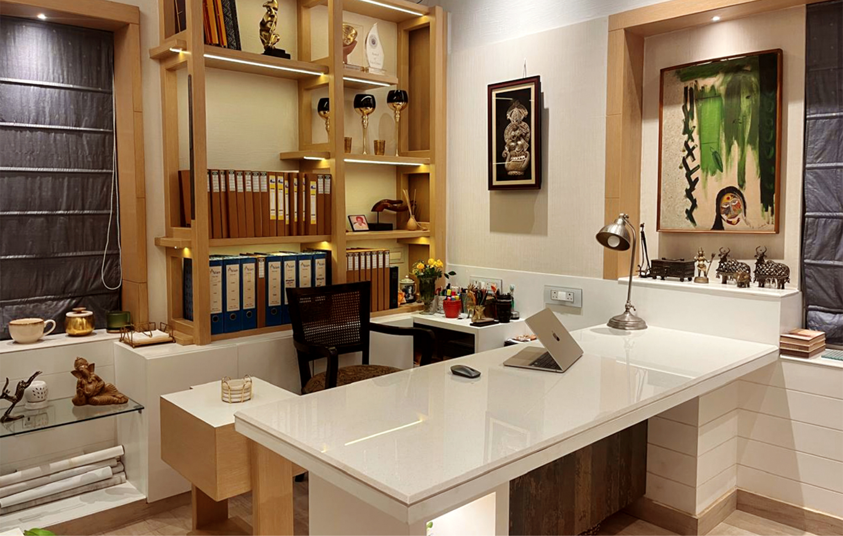 Char Chala Studio's own office interior with white marble desk, warm wood shelving and curated Bengali artwork, Kolkata