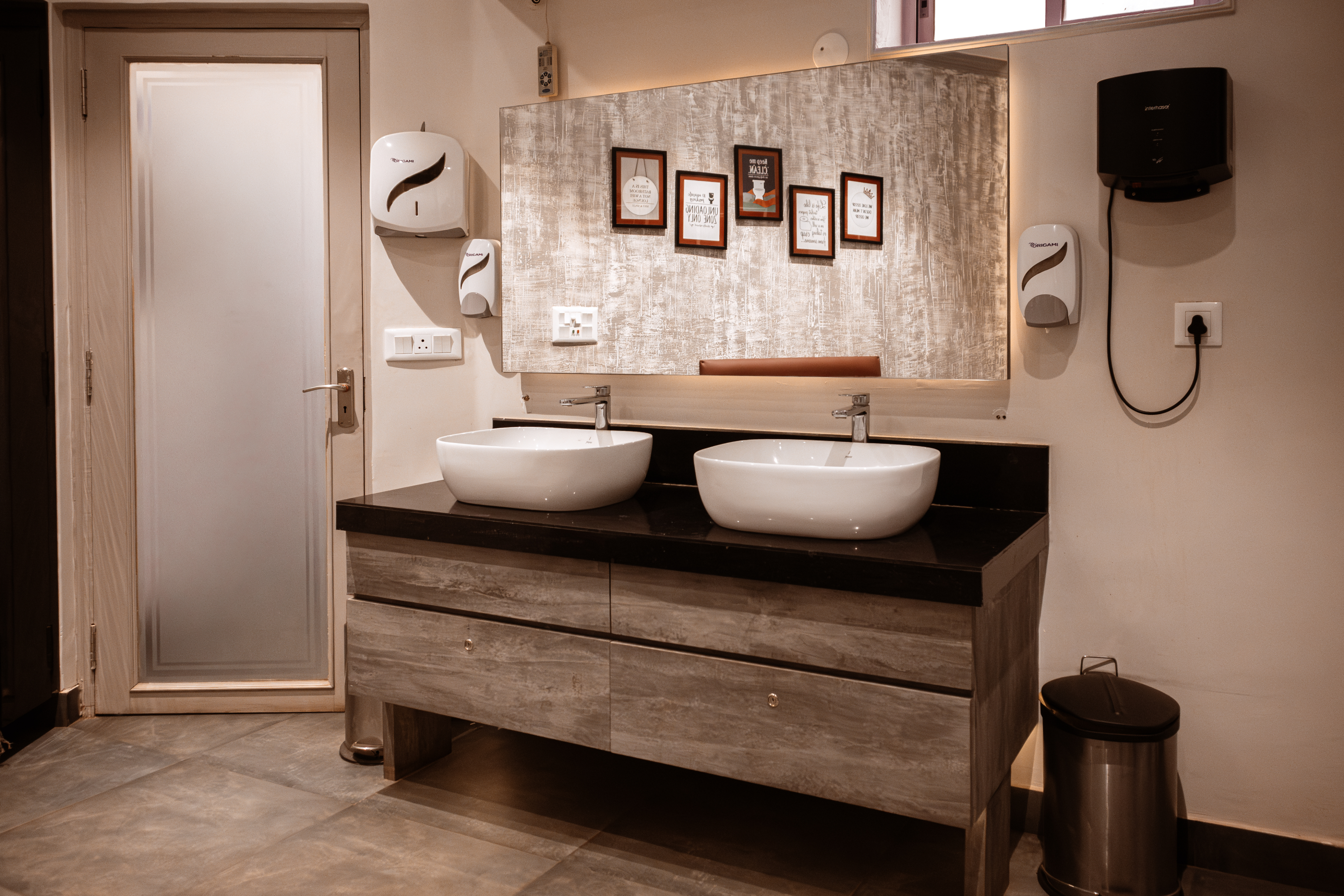 Modernised women's washroom at CCFC with dark wood vanity, vessel basins and heritage-aligned finishes